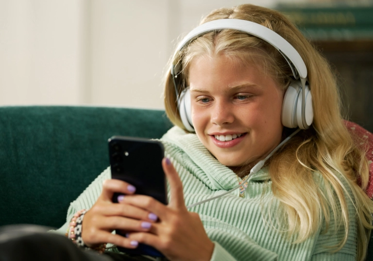 A girl using the Bark Phone, a phone for kids with built-in parental controls
